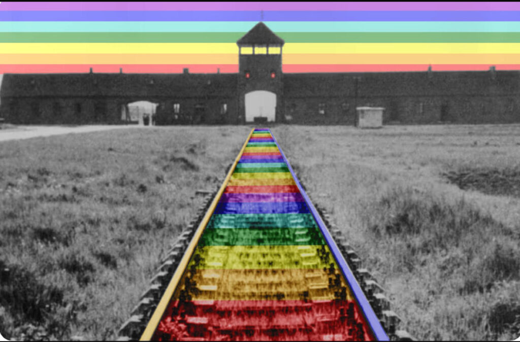 Binari colorati con i colori dell’arcobaleno conducono all’ingresso di Auschwitz, simbolo di memoria e pace