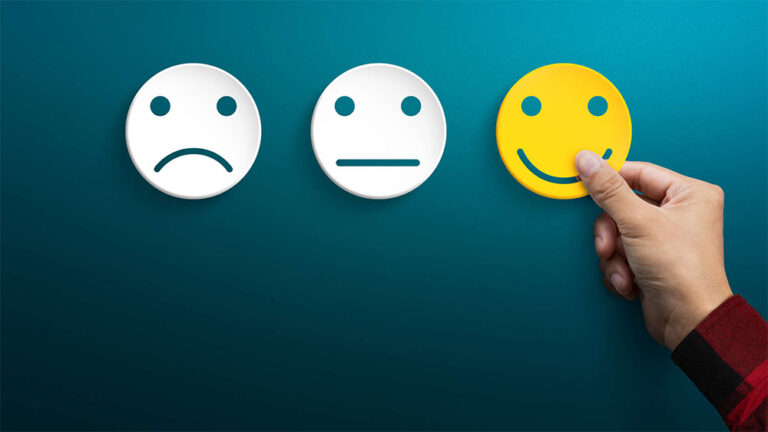 Icone di feedback: volto triste, neutro e felice. Una mano sceglie il sorriso per esprimere soddisfazione e apprezzamento