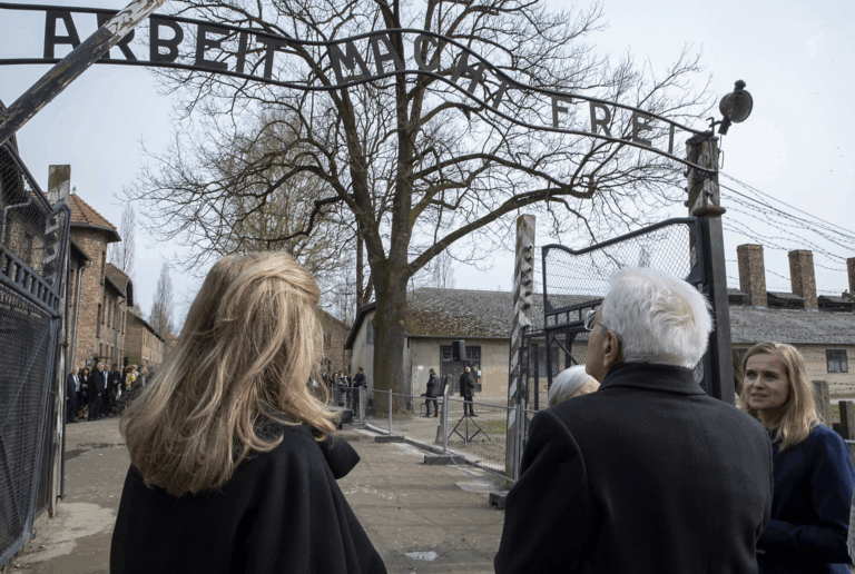Visitatori all'ingresso del campo di concentramento di Auschwitz, sotto l'insegna "Arbeit macht frei", durante la Giornata della Memoria.