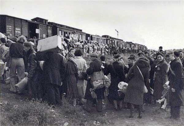 Deportazione durante la Seconda guerra mondiale: folla di persone vicino a vagoni ferroviari in attesa di essere trasportate