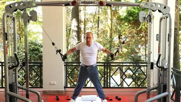 Putin si allena con macchina da palestra in veranda immersa nel verde.