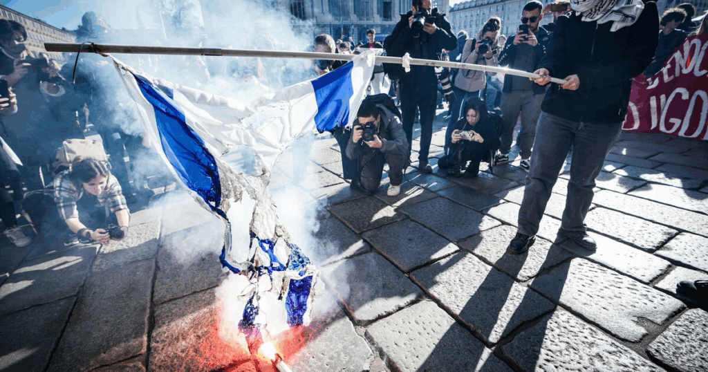 "Manifestanti bruciano una bandiera israeliana durante una protesta"