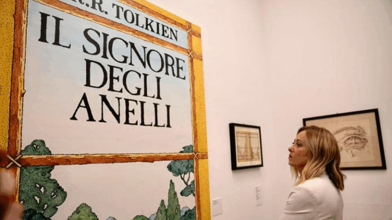 Giorgia Meloni osserva una locandina de "Il Signore degli Anelli" durante una mostra dedicata a J.R.R. Tolkien.