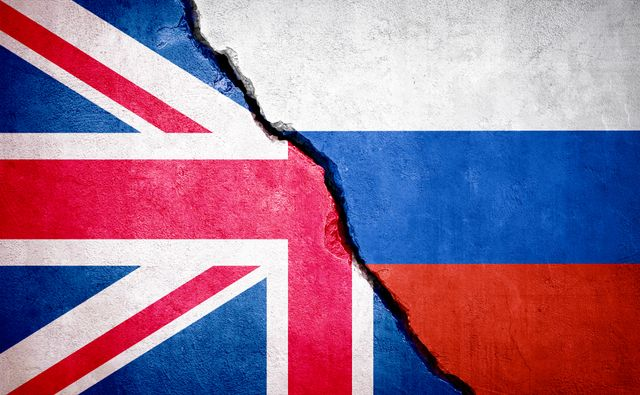 Bandiera del Regno Unito e bandiera russa divise da una frattura, simbolo della crescente tensione tra UK e Russia.