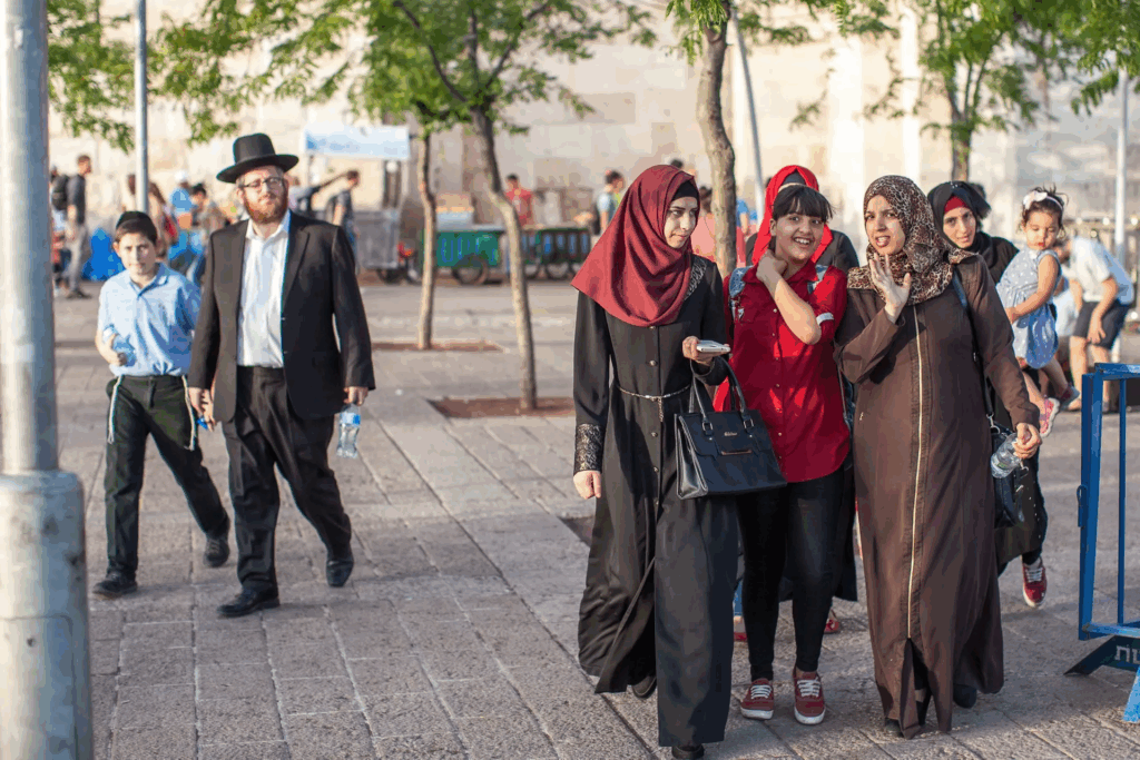 Ebrei ortodossi e donne arabe convivono nello spazio urbano di una città israeliana, simbolo di diversità culturale e coesistenza