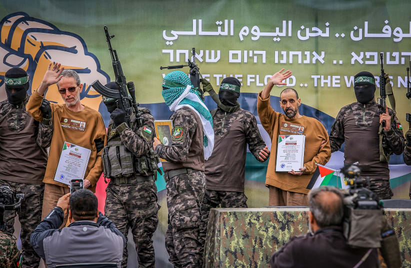 "Ostaggi israeliani rilasciati da Hamas, mostrati pubblicamente accanto a miliziani armati mascherati durante una messa in scena propagandistica."