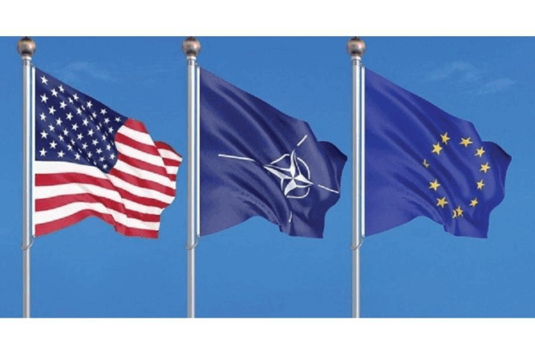 Bandiere di USA, NATO e Unione Europea: simbolo delle relazioni transatlantiche e della cooperazione strategica tra Europa e alleati occidentali.