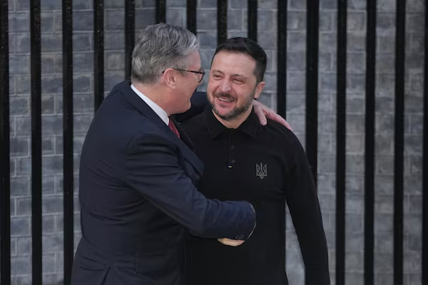Stretta di mano tra un politico britannico e Volodymyr Zelensky, simbolo di sostegno e dialogo internazionale