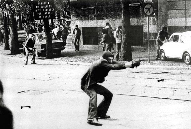 Giovane manifestante armato durante gli scontri urbani in Italia negli anni di piombo, simbolo della violenza politica del Novecento.