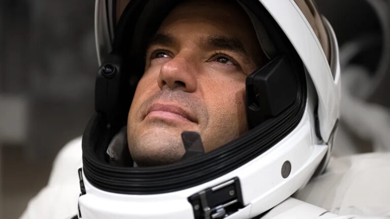Astronauta in tuta spaziale moderna guarda verso l’alto, simbolo della nuova corsa alla Luna guidata da USA e SpaceX.
