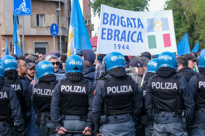 Polizia schierata davanti a manifestanti con bandiera della Brigata Ebraica durante il corteo del 25 aprile in Italia