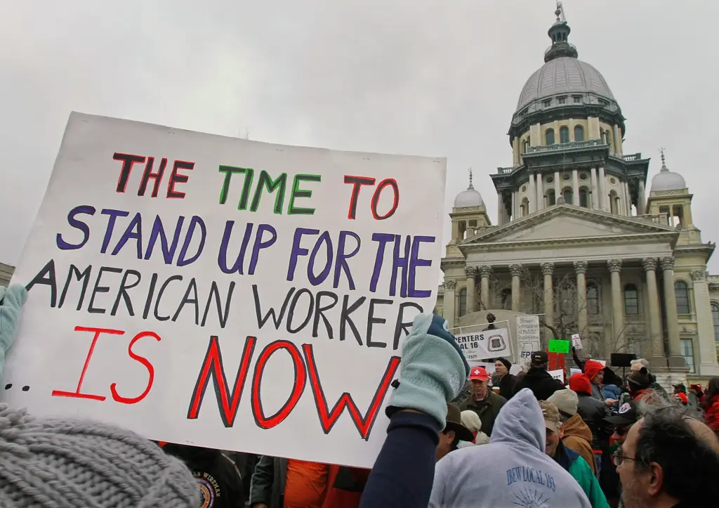 Manifestazione contro la globalizzazione davanti a un edificio pubblico, con cartello a sostegno dei lavoratori americani e contro i dazi di Trump