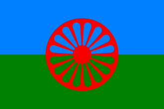 Bandiera rom con ruota rossa su sfondo blu e verde, simbolo di identità e libertà del popolo romanì