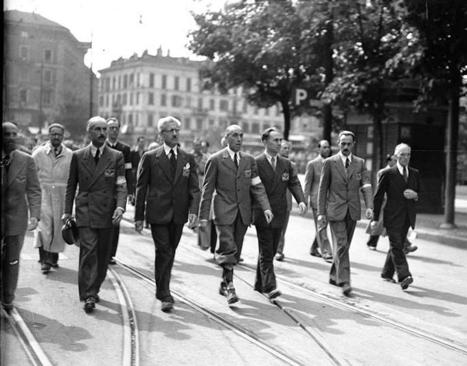 Milano, 1945: membri del CLN sfilano dopo la Liberazione. Immagine simbolo del 25 aprile e del pluralismo della Resistenza italiana.