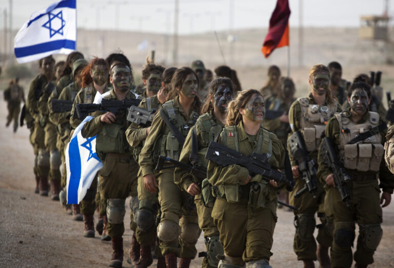 Soldatesse israeliane in marcia con bandiere: simbolo di coraggio e difesa durante l’attacco da Gaza del 7 ottobre 2023