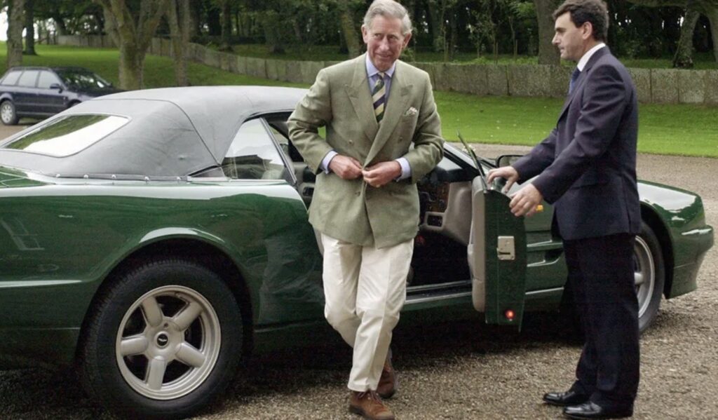 Stile maschile creativo: Carlo III in blazer verde scende da un’auto sportiva con disinvoltura